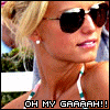 A pixelated image of a person with blonde hair wearing dark sunglasses and small earrings, in profile view.