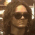 five pixelated images showing a person with long brown hair and sunglasses in various poses, including one wearing a hat