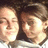 Two pixelated human faces in close-up, side-by-side against a dark background with light highlights on their skin.
