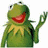 Green frog puppet with red mouth and yellow collar in three distinct poses against white, black, and gray backgrounds.