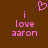 Brown background with pink pixelated text reading "i love aaron" and a pink heart symbol above the text.