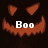 Pixelated orange pumpkin face with triangular eyes and jagged mouth, white 'Boo' text centered below the mouth on a dark background.