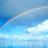 Pixelated rainbow arcs across blue sky with white clouds; yellow text reads 'What relly at the other end of the rainbow' on black background.