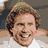 A pixelated image of a smiling person with brown hair and light skin, next to red text on green background asking 'can i give you a hug?!'