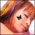 Pixelated close-up of a person with reddish-brown hair wearing a colorful striped headband, closed eyes, and a black butterfly symbol on the forehead.