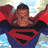 Pixelated image of a figure in blue and red costume with cape, standing against sky background, next to text reading "I'LL BE YOUR SUPER MAN".