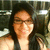 Pixelated static image of a person with long dark hair wearing glasses and a sleeveless top against a blurred background.