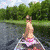 Animated sequence showing a person in a canoe, then a man with arms crossed against a sunset, and finally a woman indoors; all scenes are pixelated.