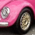 Pixelated close-up of a pink vehicle's front section showing headlight and wheel with visible tire tread, rendered in low-resolution 256x256 pixels.