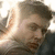 A pixelated image of a person with short brown hair in three , the right displaying text overlay