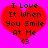 Red heart-shaped graphic with black text reading "I Love It When You Smile At Me" on bright pink background, featuring a small heart symbol at bottom center.