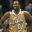 Pixelated image of a basketball player in a gold jersey with white trim and number 0, standing with arms crossed against a dark background.