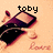 A pixelated image shows a dark purple and black object with light brown accents on an orange background, featuring text above it that changes across frames.
