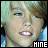 Pixelated static image of a person's face with visible teeth and partial hair, featuring the word "HINE" in white block letters at bottom right corner on dark background.