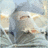 Pixelated static image of a figure with light hair and dark clothing against a gradient sky background.