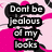 Pixelated text in black rectangular blocks on a pink and white background reads "Don't be jealous of my looks" with a pink star-like shape above the text.