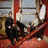 Four distinct views of a group of people in formal attire against red and dark backgrounds, with visible pixelation.