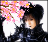 A person with dark hair in a high bun wears a black high-collared outfit, with pink cherry blossoms and petals floating around them against a white background.