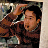 Static 48x48 pixel buddy icon showing a man in brown clothing with dark hair, partially cropped on the right side against a blurred background.