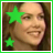A pixelated portrait of a smiling person with long dark hair, overlaid by two bright green stars on the left side.