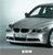 Pixelated silver car with dark windows and black grille, angled front view against light gray background, small white rectangular element at bottom center.