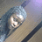 Pixelated image of a person with light hair and a blue background featuring green text on red.