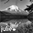 Black-and-white landscape of a mountain with reflection in water, overlaid text 'julie' and star symbol changing color across frames.