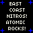 Pixelated text displays 'EAST COAST HITROS! ATOMIC ROCKS!' in white on black with blue stars, repeated twice vertically.