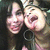 Two people with dark hair pose closely together, one with mouth open in a laugh, the other smiling, in a pixelated animated sequence.