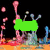 Animated icon with green and purple elements, pink shapes on left, blue and orange background details.