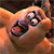A pixelated close-up of a cartoon animal face with large eyes and an open mouth, rendered in warm orange and brown tones.