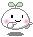 Pixelated character with white rounded body, green leaf-like top, pink cheeks, black eyes, and gray limbs on gray background.