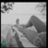 Grayscale pixelated image with abstract shapes and a small green square in the bottom-left corner, no visible text or distinct subjects.