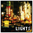 Animated sequence showing a cityscape at night with illuminated buildings and streetlights, transitioning between text labels 'LIGHTS', 'CAMERA', and 'ACTION' in the lower-left corner.