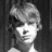 Black-and-white pixelated image of a person with light hair against dark background, next to text reading 'Jared Blair' in blocky font.