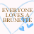 Static pixel art icon featuring brown text reading "EVERYONE LOVES A BRUNETTE" inside a light blue heart outline with two small blue hearts at the bottom right, on a white background.