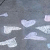 A static image of repeated heart-shaped icons with text overlays on a gray background.