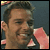 Static pixelated image of a person's face with visible facial features and partial clothing, rendered in low resolution with dithering effects on the background.