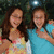 Two people pose together in a pixelated image with green text overlays on pink and gray backgrounds.