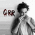 A grayscale animated icon shows a person with curly hair in a striped jacket, holding hands near the chest; 'GRR' text appears left of the figure.