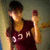 A person in a maroon shirt with white text holds a small object, captured across showing slight movement