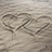 A pixelated image shows two heart shapes drawn in sand with the name 'jordan' in blocky text below, followed by a small heart symbol.