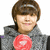 Pixelated portrait of a person with brown hair wearing a gray jacket and red circular emblem on chest.