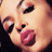 Pixelated close-up of a person's face showing eyes, nose, and lips with visible dithering and color blending in warm tones.