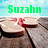 Green text 'Suzahn' above a pixelated image of a hand holding a wine glass with red liquid spilling over the rim.