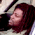 A person with long dark hair appears in three distinct poses: reclining with eyes closed, facing forward with a neutral expression, and turned in profile with a light-colored head covering.
