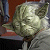 Static 50x50 pixel icon depicting a cartoon character with green skin, large ears, and closed eyes in a meditative pose against a blurred background.