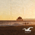 A static scene with a seagull flying over water, a distant structure on the horizon, and a gradient sky transitioning from light to dark yellow.