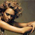 Pixelated image of a person with light brown hair and dark clothing, holding a long light-colored object horizontally.
