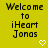 Yellow background with black pixelated text reading "Welcome to iHeart Jonas" and a white pixelated heart symbol below the text.